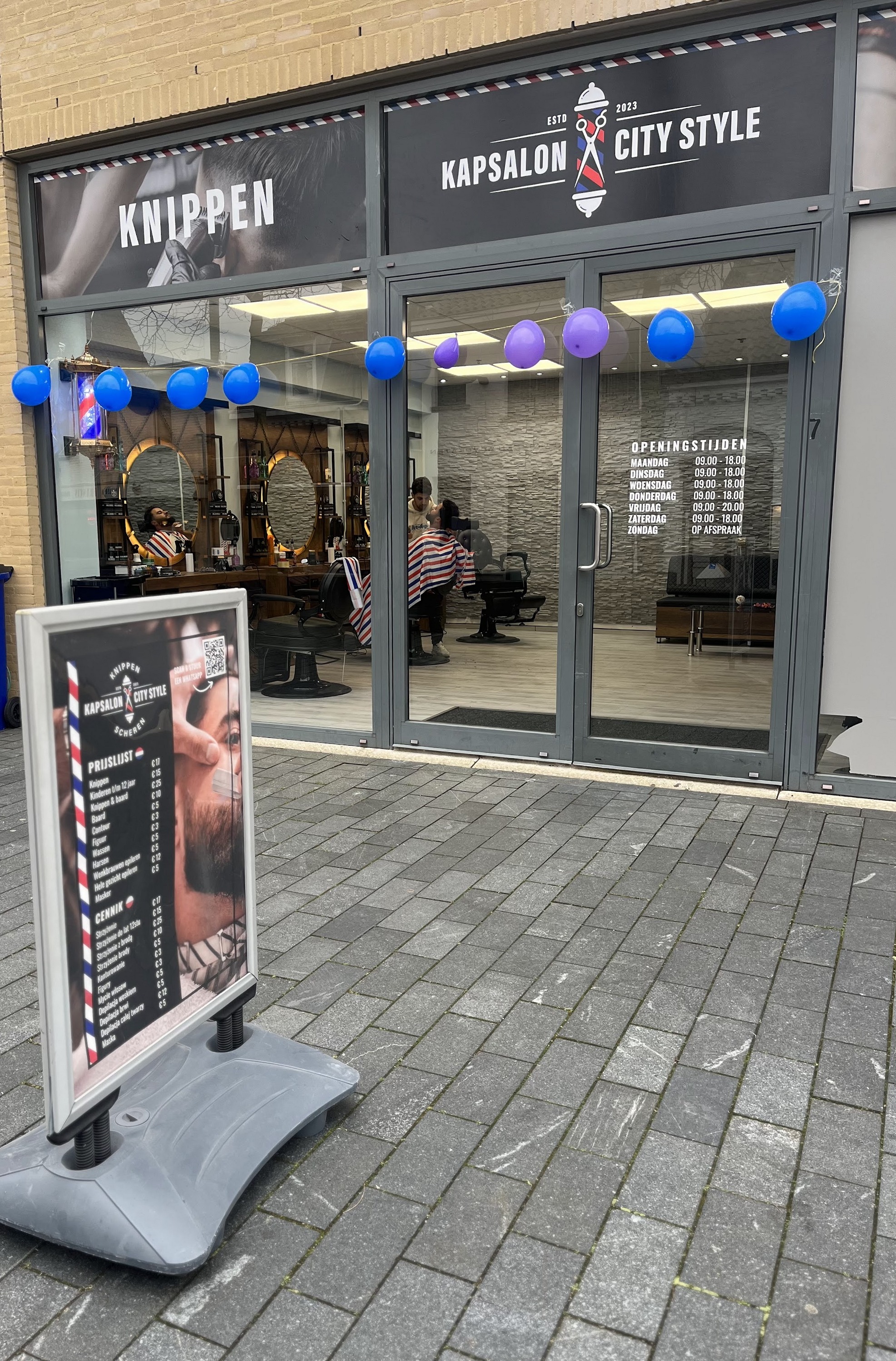 De ingang van City Style met het kappersbord voor de deur